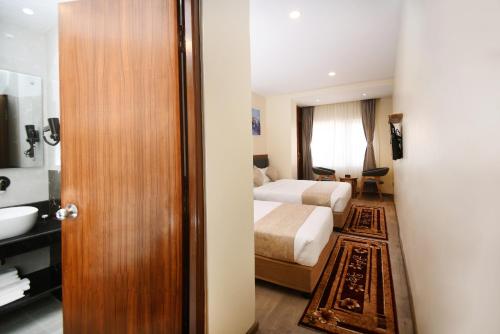 a hotel room with a bed and a bathroom at Hotel Cozy Heaven in Kathmandu