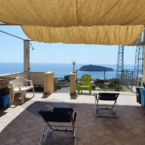 a patio with two chairs and a large umbrella at Da Peppino Diamante in Diamante