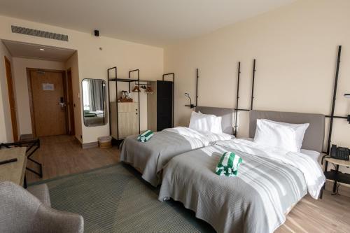 a bedroom with two beds with white sheets and a chair at The Kaktus Somabay in Hurghada