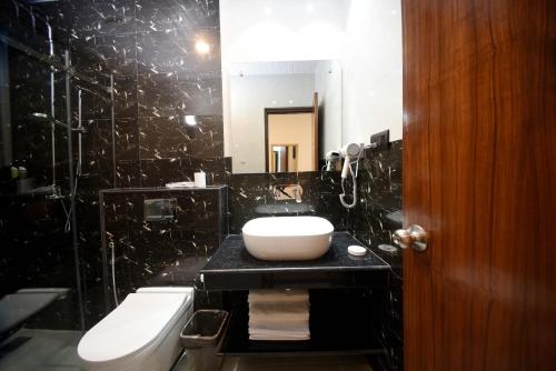 a bathroom with a sink and a toilet and a mirror at Hotel Cozy Heaven in Kathmandu
