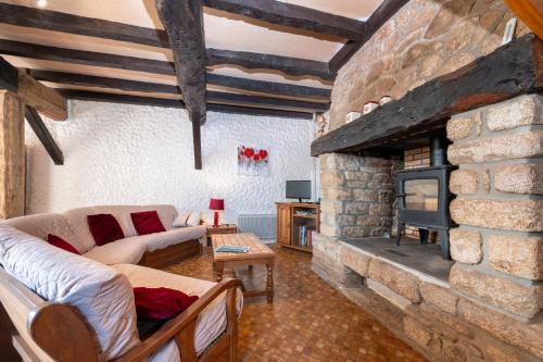 ein Wohnzimmer mit einem Steinkamin und einem Sofa in der Unterkunft Gîte à la ferme de Questembert in Questembert