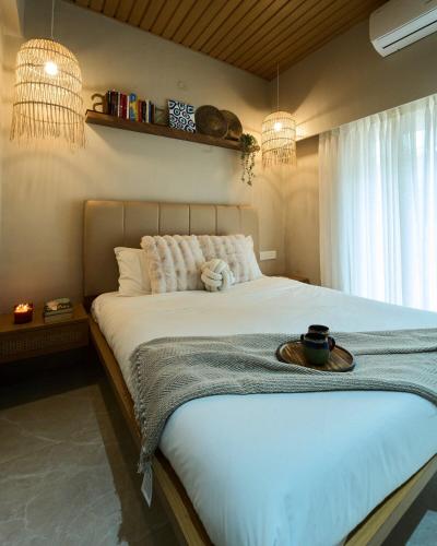 Un dormitorio con una gran cama blanca con dos luces. en Miraya Villa, en Malavli