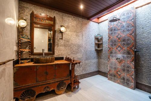 a bathroom with a sink and a mirror at Villa Joglo Ayu in Uluwatu