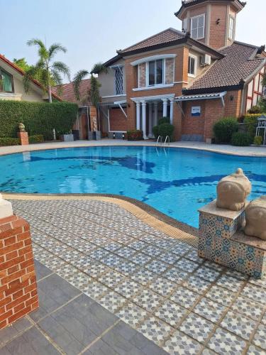 a swimming pool in front of a house at Rosie Garden & Home in Ban Bung