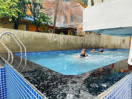 a group of people swimming in a swimming pool at Harsh angel holiday homes in Calangute