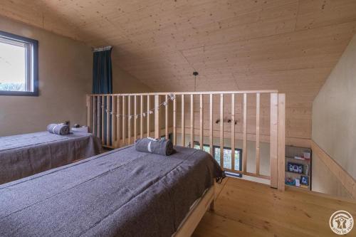 a bedroom with two beds and a window at La joline, maison bioclimatique in Montastruc-de-Salies