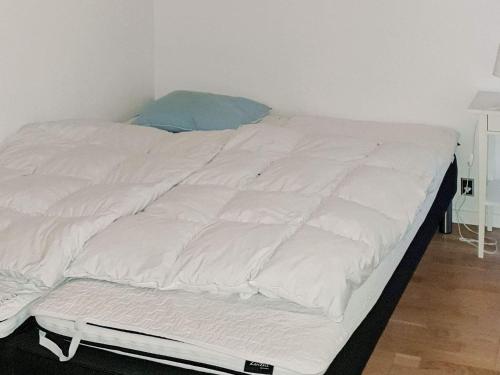 a large white bed with a blue pillow on it at 8 person holiday home in Sydals in Mommark