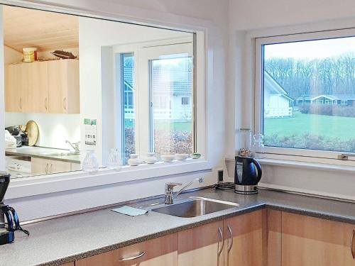 a kitchen with a sink and a large window at 8 person holiday home in Sydals in Mommark