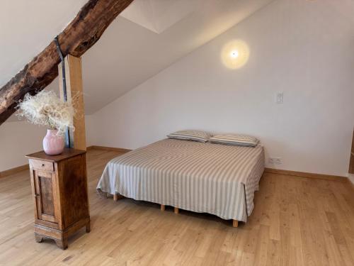 a bedroom with a bed and a wooden floor at Confort et élégance au cœur de Florac in Florac Trois Riviere