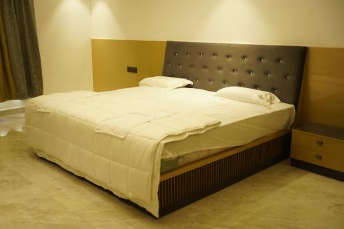 a bedroom with a large bed with white sheets at A79 Hotel in Chennai