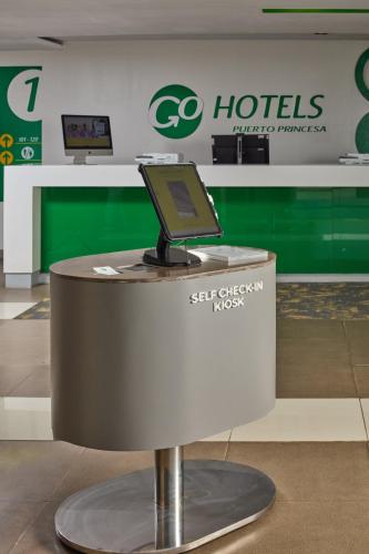 a table with a laptop sitting on top of it at Go Hotels Puerto Princesa in Puerto Princesa City