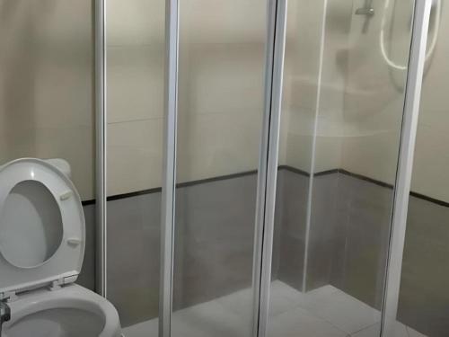 a shower stall with a toilet in a bathroom at Loong Fatt Hotel in Sungkai