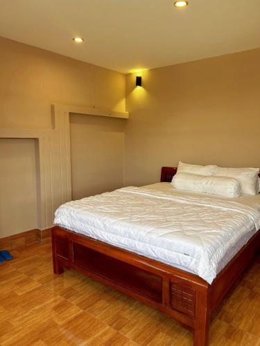 a bedroom with a large bed with white sheets at Lakeside Đá Bàng Ecolodge, ấp Tân Hiệp, xã Long Tân, Huyện Đất Đỏ, BRVT in La Sơn