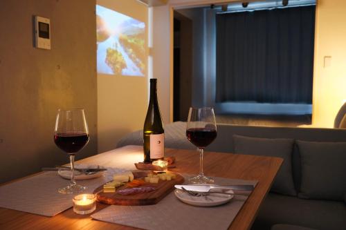 a bottle of wine and two glasses on a table at Monzen-nakacho 1LDK with projector, 2 double beds,301 in Tokyo