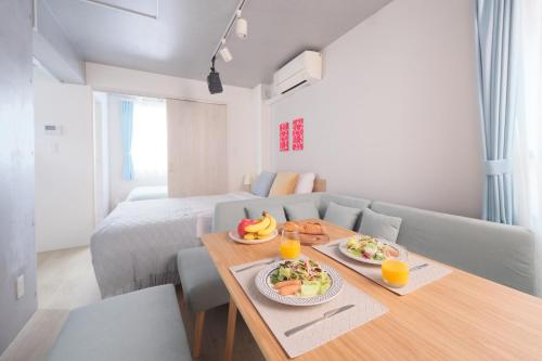 a room with a table with plates of food on it at Monzen-nakacho 1LDK with projector, 2 double beds,301 in Tokyo