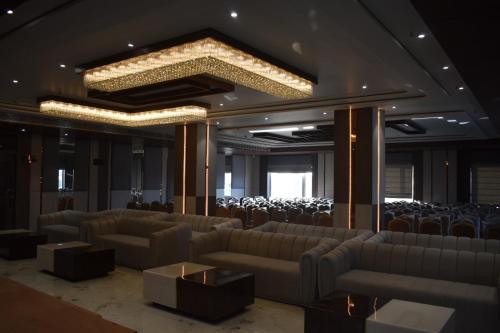 a conference room with couches and chairs and a chandelier at Nirvana Grand Hotel & Resort in Gaya
