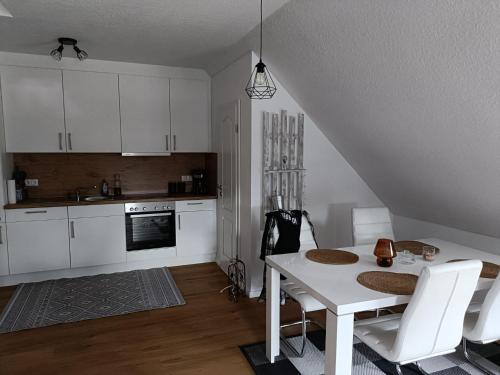 una cucina con tavolo bianco e armadietti bianchi di Ferienwohnung1 Monteurwohnung Nordsee ad Aurich