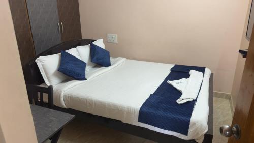 a bedroom with a bed with blue and white pillows at Venisha Residency Tirupati operated by Alexa in Tirupati