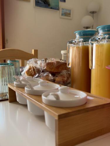 a wooden tray with four white plates and some drinks at B&B Porta Verde in Castelbottaccio