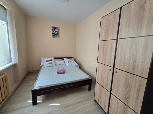 a small bedroom with a bed and a large cabinet at Апартаменти CENTER in Uzhhorod