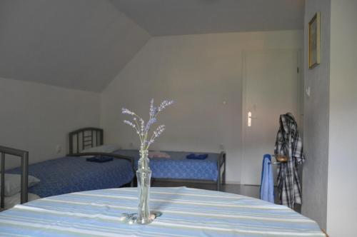 a vase on a table in a room with two beds at Simpli Apartments in Ljubljana