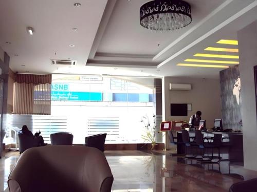 an office with chairs and a person sitting at a desk at MB Hotel in Tawau