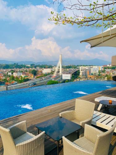a view of a swimming pool with chairs and a table at Grandia Hotel in Bandung