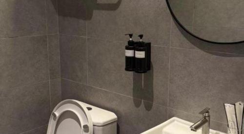 a bathroom with a toilet and a sink and a mirror at Hotel Zamburger Bentong in Bentong