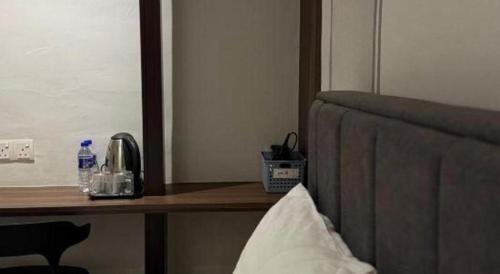 a room with a desk with a chair and a table with a counter sidx sidx at Hotel Zamburger Bentong in Bentong