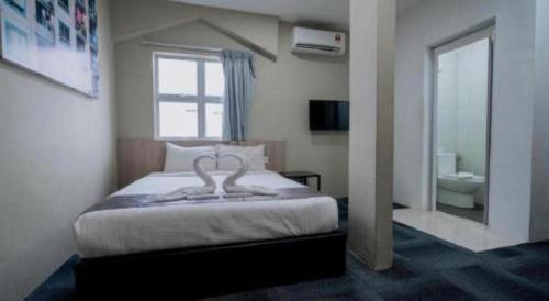 a bedroom with a bed and a large window at Kimal Hotel Taiping in Taiping