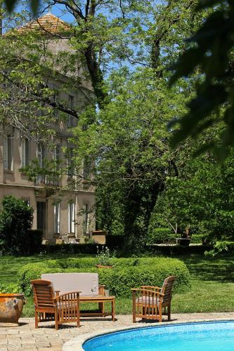 - un groupe de chaises et une table à côté de la piscine dans l'établissement Domaine de la Célarié, à Mouzieys-Teulet