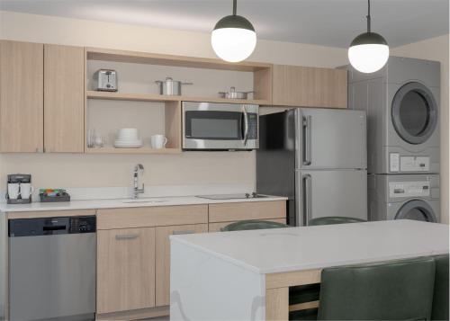 a kitchen with a refrigerator and a microwave at Homewood Suites By Hilton Viera Melbourne in Melbourne