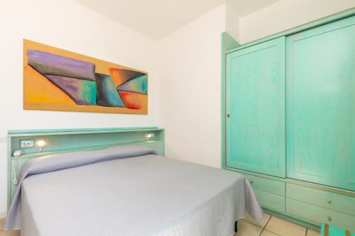 a bedroom with a bed and a painting on the wall at Hotel Marinaro in Santa Teresa Gallura