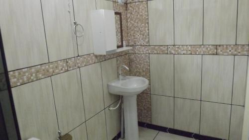 a bathroom with a white sink and a mirror at Pousada Bom Futuro in Penha