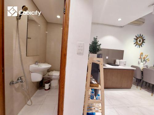 a bathroom with a toilet and a sink and a ladder at Cubicity Hidden House in Ho Chi Minh City