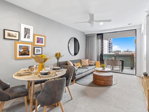 a living room with a couch and a table at Lux 2BR Apt 5 Stars Hotel Pool Gym 10 min CBD in Brisbane