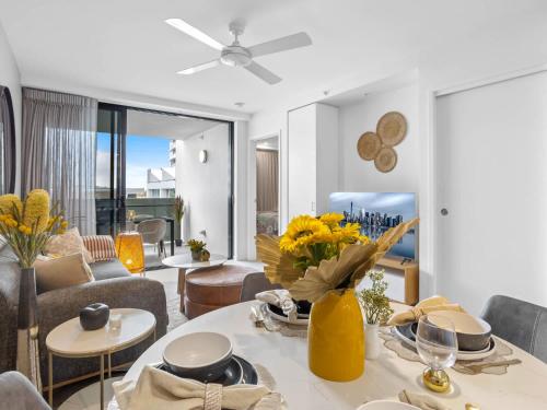 a living room with a table with yellow vases at Lux 2BR Apt 5 Stars Hotel Pool Gym 10 min CBD in Brisbane