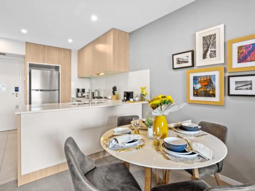 a kitchen and dining room with a table and chairs at Lux 2BR Apt 5 Stars Hotel Pool Gym 10 min CBD in Brisbane