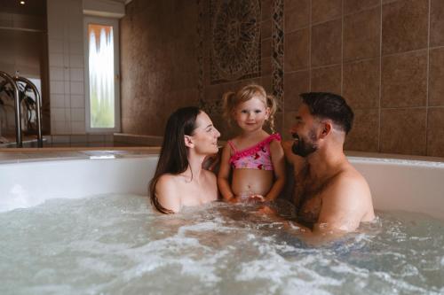 a man and a woman and a girl in a bathtub at Hotel Solisko in Štrbské Pleso