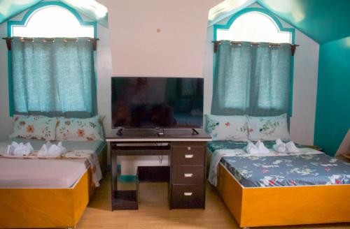 a room with two beds and a desk and a sink at Casa De Moore - Ocean & Garden View Siargao in General Luna