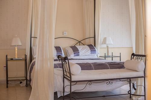 a bedroom with a bed and a chair and two lamps at Villa Pelagia Secret Valley Paphos in Kouklia