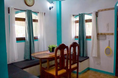 a dining room with a table and two chairs at Casa De Moore - Ocean & Garden View Siargao in General Luna