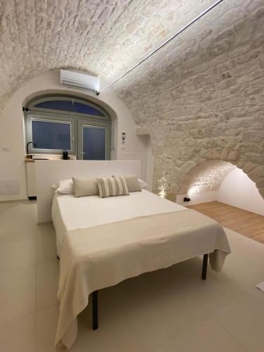 a bedroom with a bed and a stone wall at Suite Prima Pietra with mini pool in Ostuni