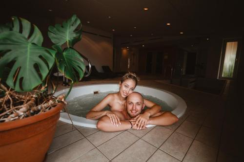 a man and a woman laying in a bath tub at Hotel Solisko in Štrbské Pleso