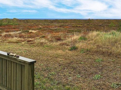 a field of grass with a wooden fence and a field of grass at 6 person holiday home in Læsø in Læsø