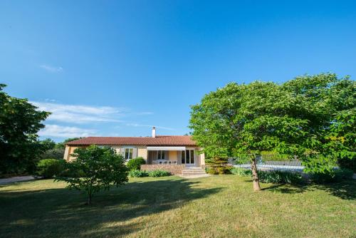 a house with a tree in the yard at Villas de La Ferme Du Gros Noyer in Malaucène