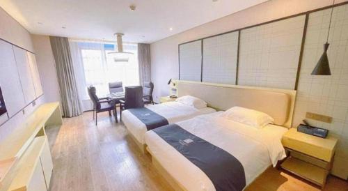 a hotel room with a large bed and a desk at Echarm Hotel Taizhou International Convention and Exhibition Center 