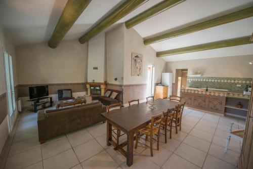 a living room with a table and a couch at Villas de La Ferme Du Gros Noyer in Malaucène