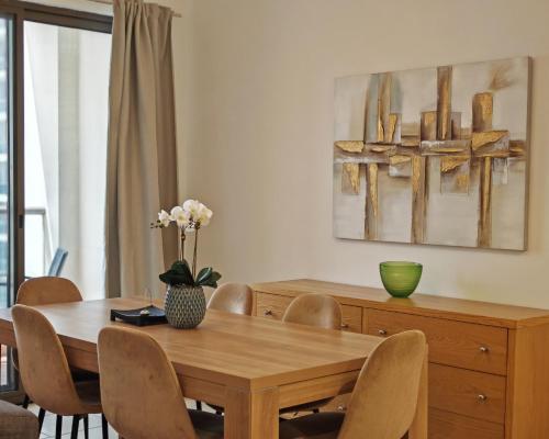 a dining room with a wooden table and chairs at Beautiful 2BR & 4BR Apartments on JBR Beach, Walking Distance to Bluewaters Island - By Sunkissed Holiday Homes in Dubai