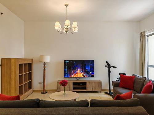 a living room with a couch and a tv at Beautiful 2BR & 4BR Apartments on JBR Beach, Walking Distance to Bluewaters Island - By Sunkissed Holiday Homes in Dubai